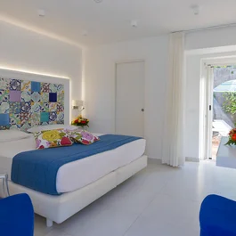 Camera da letto luminosa con letto matrimoniale e porta finestra su terrazza