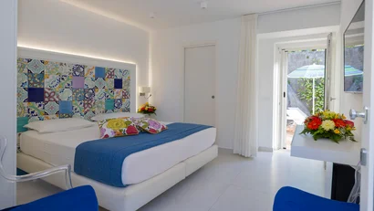 Camera da letto luminosa con letto matrimoniale e porta finestra su terrazza