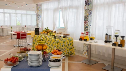 Buffet colazione con frutta fresca, succhi e dolci in sala luminosa