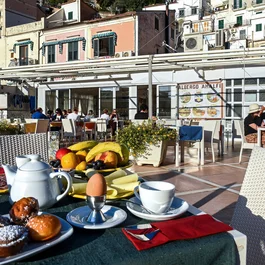 Breakfast with pastries, fruit, and coffee on a sunny restaurant terrace