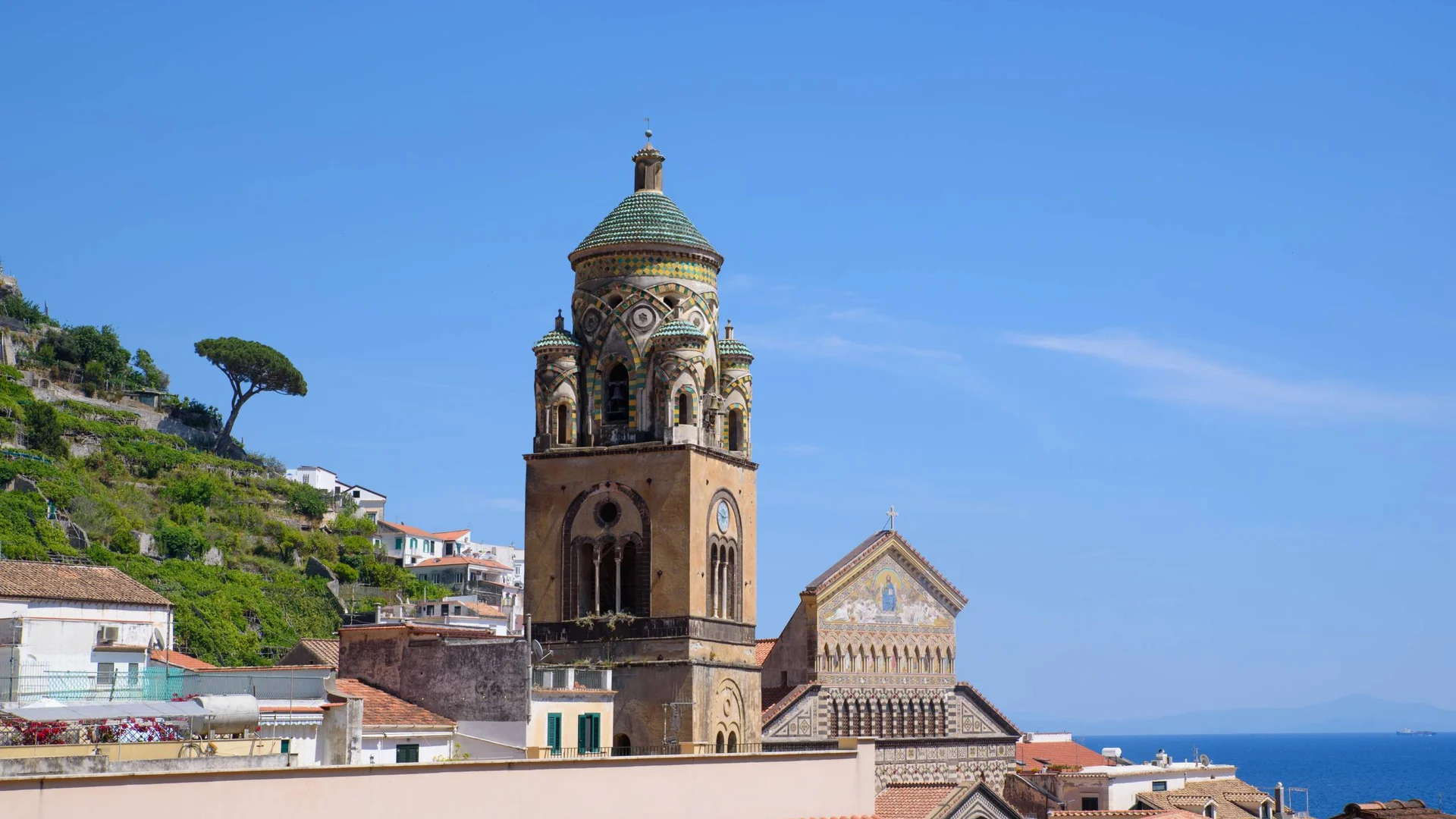 Bell tower and church with decorative details against blue sky